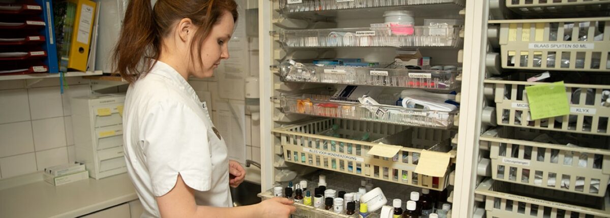 Medicijnkamer met medewerker Medewerker aan het werk in de medicijnkamer